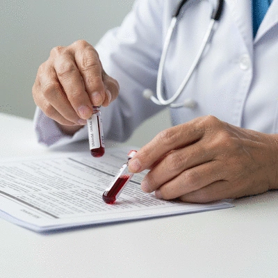 Close-up of hands holding blood test vials and a medical chart, symbolizing thyroid function tests and monitoring