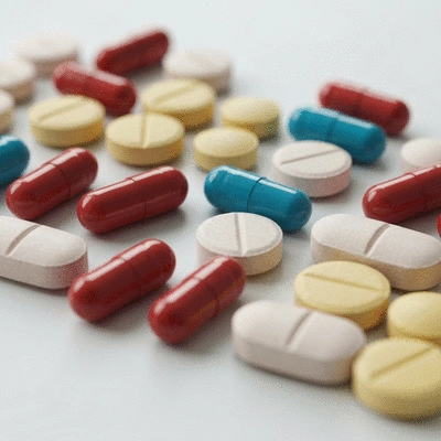Close-up of various thyroid medication pills and capsules on a clean white surface, showcasing different shapes and colors, no text, no words, no typography, clean image